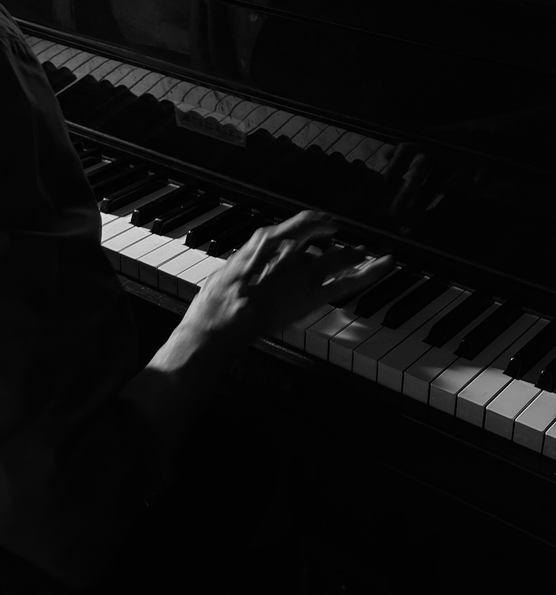 Person spielt bei schwachem Licht Klavier
